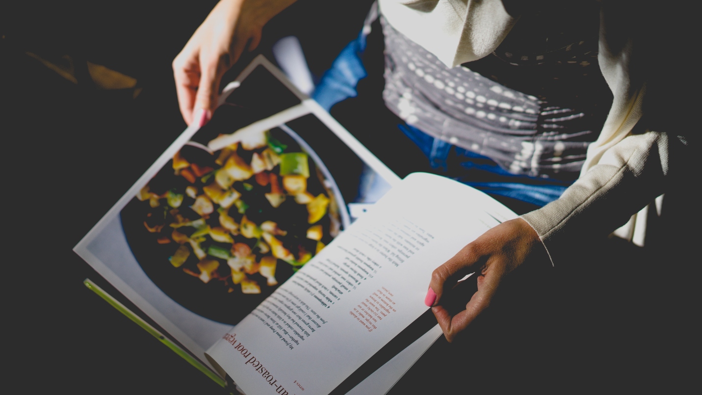 man-in-jeans-holding-recipe-book