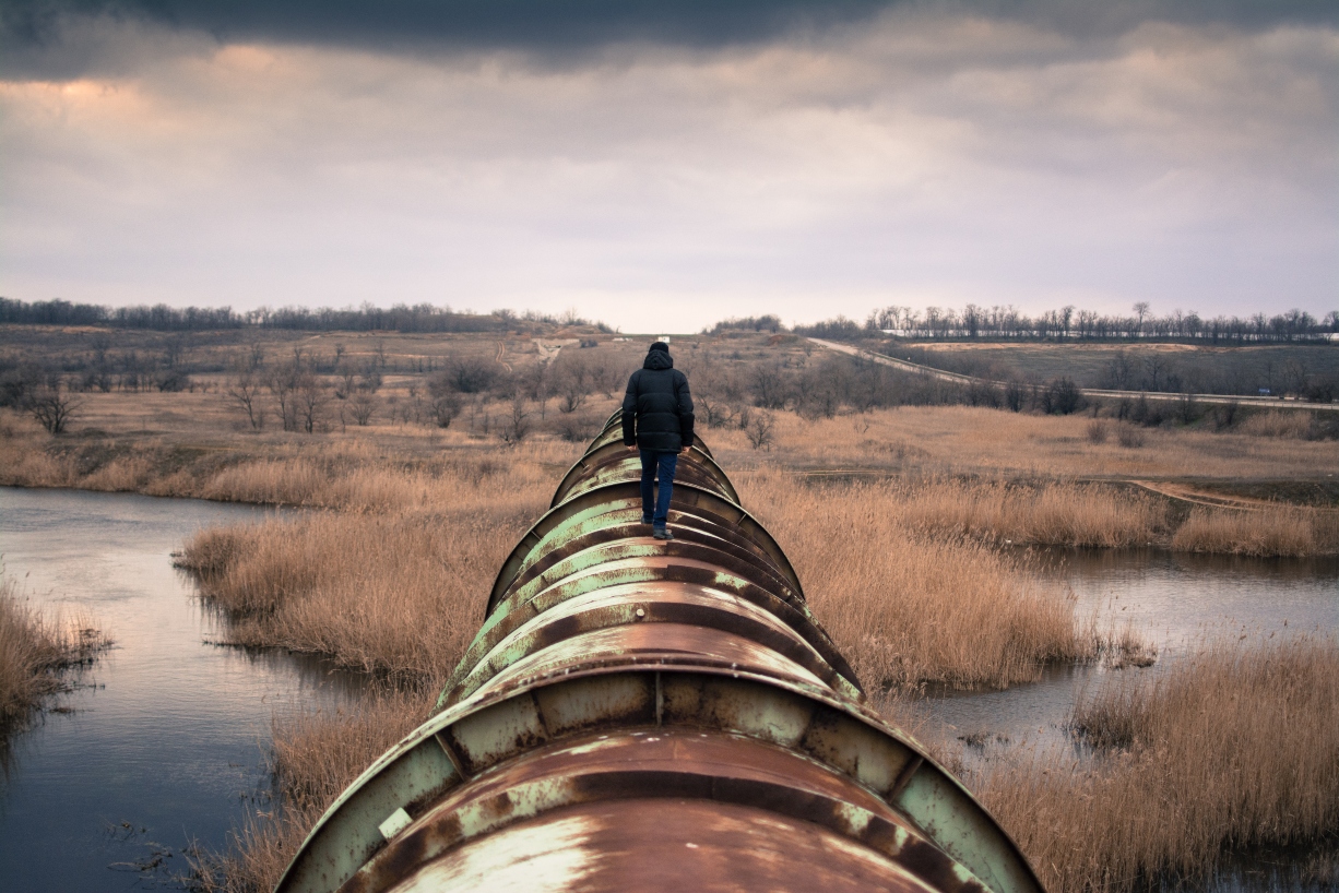 person-walking-on-top-of-water-pipe