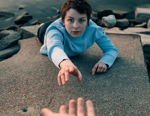 woman reaching towards outstretched hand